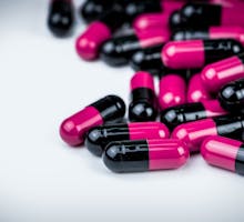 Pink-black Capsule Pills On White Table