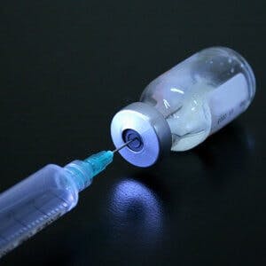 a syringe in a vial of medicine