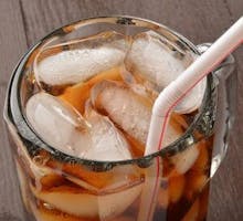 Close up of a soda in a mug with a straw
