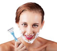 Woman using razor to shave unwanted facial hair
