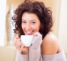 Young woman at home sipping Oolong tea from a cup